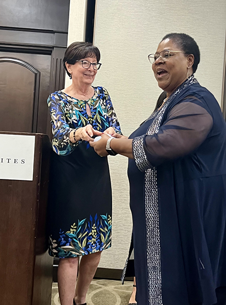 Josephine Gilbert (right) receives her raffle prize, a Gemtec Australian Black Opal earrings and pendant set, from Mary Weber, chairman of the MACCW Scholarship Committee on Saturday, Feb. 24, 2024, in Fort Lauderdale. The raffle was part of the fundraiser towards the MACCW Lucy Petrillo Scholarship Fund for young women to attend Catholic high school.