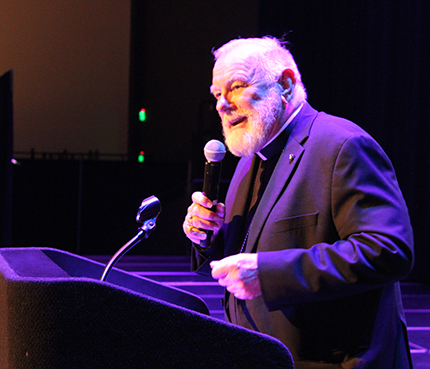 Archbishop Thomas Wenski provides opening remarks and prayer at the Greater Love Conference on Mar. 6, 2024, for the nearly 2,000 archdiocesan school eighth graders in attendance at the Charles F. Dodge City Center in Pembroke Pines. The event was organized by the Office of Evangelization and Parish Life.