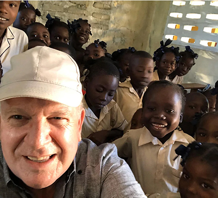 El P. Federico Capdepón posa con un grupo de niños beneficiarios de la organización KèPoze for Haití, en la diócesis de Fort Liberté.