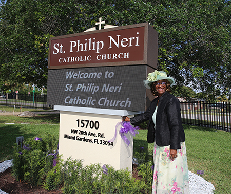 Constance Thornton, a parishioner for 70 years, cuts the ribbon during the dedication and blessing of new pews and a new digital sign at St. Philip Neri Church, Miami Gardens, March 17, 2024.