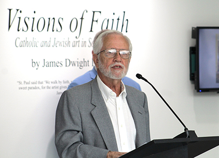 Photographer Jim Davis speaks at the 'Visions of Faith' interfaith sacred art exhibit unveiling at St. Thomas University's Rev. Jorge A. Sardiñas Gallery on March 12, 2024. The exhibit showcases photographs taken in Catholic churches and synagogues in South Florida.