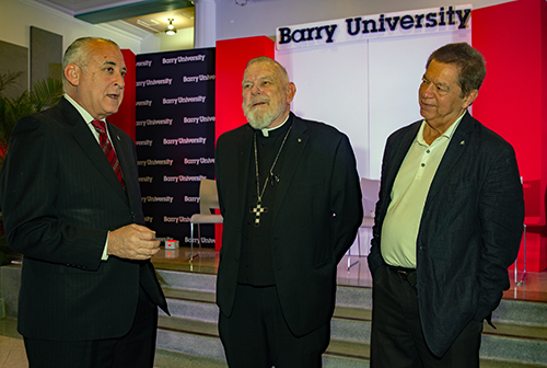 From left: Esteban Bovo, mayor of Hialeah; Archbishop Thomas Wenski and Peter Routsis-Arroyo, executive director of Catholic Charities of Miami speak after a panel discussion, March 21, 2024, at immigration conference at Barry University.