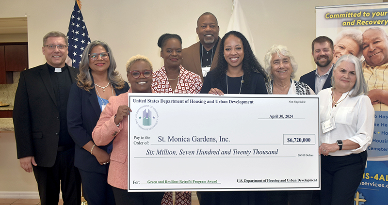 Officials pose April 30 with a $ 6.72 million check from the U.S. Department of Housing and Urban Development for improving group homes managed by the Archdiocese of Miami. From left are Msgr. Dariusz Zielonka, archdiocesan chancellor for canonical affairs; Juana D. Mejia, vice president of housing development and operations, Catholic Housing Management; Jennifer Riley Collins, HUD regional administrator; Alexis Snyder, deputy chief of staff for Congresswoman Frederica Wilson; Mayor Rodney Harris of Miami Gardens; Tiffany Cobb, HUD deputy regional administrator; Margarita Polo, a resident of St. Monica Gardens; Mark Dominick, HUD regional director for multifamily housing; and Isabel Soto-Noriega, property manager of St. Monica Gardens.