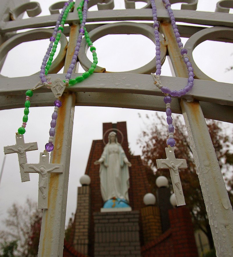 Rosaries hang on a fence guarding a statue of the Virgin Mary that believers say is crying blood on the outskirts of Sacramento, California, Dec. 1, 2005. (OSV News photo/Kimberly White, Reuters)