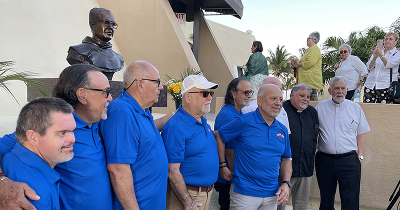 A group of Children of Father Camiñas, now grandparents, pose for a photo in front of the bust of the Franciscan friar at the Shrine of Our Lady of Charity in Miami April 25, 2024. With them from right are; Father José Luis Menéndez, pastor of Corpus Christi in Miami; Father José Espino, rector of the Shrine; and also in the picture is Father Federico Capdepón, a retired priest from Miami.