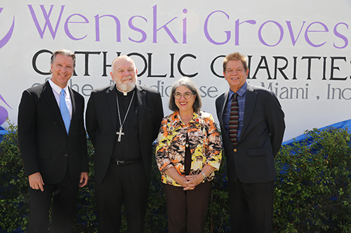 From left: Philip Sylvester, entrepreneur/developer; Archbishop Thomas Wenski; Miami-Dade Mayor Daniela Levine-Cava; and Peter Routsis-Arroyo, CEO of Catholic Charities of Miami, pose by a mural created for Wenski Groves, an affordable housing complex of Catholic Charities, during a blessing and ribbon-cutting ceremony April 26, 2024. The complex includes 30 apartments, 20 efficiencies, and 10 single-bedroom spaces. The mural was created by artist Erni Vales.
