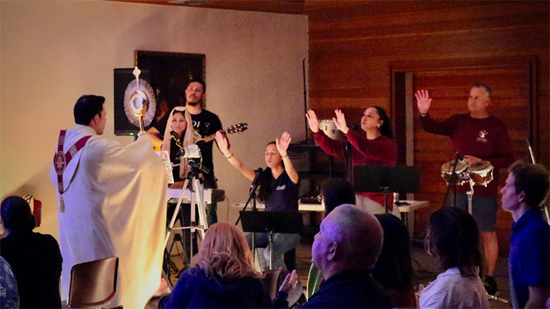 Father Nicholas Toledo, Parochial Vicar at St. John Neumann Parish, brings the Eucharist near the Adore Praise & Worship band during an Adoration Night Feb. 17, 2024, at St. Louis Church.