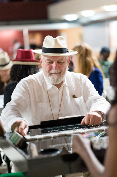 Archbishop Thomas Wenski makes a move during a game of dominos at the annual Havana Nights fundraiser for Catholic Charities' Unaccompanied Minors Program. The event took place May 3, 2024,
in the courtyard in front of the Chapel of Our Lady of La Merced, at Corpus Christi Church in Miami.