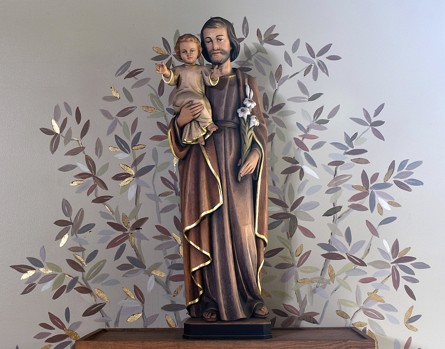 Green, gold and brown leaves surround a statuette of St. Joseph and the Christ Child on the chancel at Mary Help of Christians Church in Parkland.