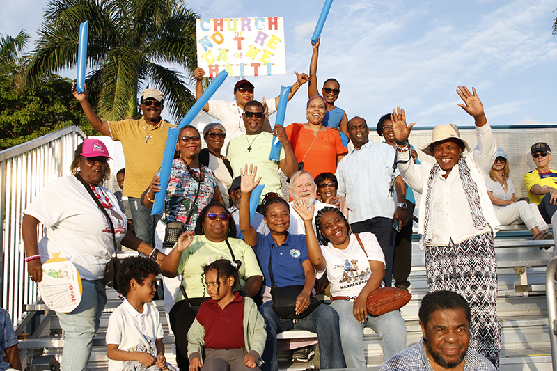 Archbishop Thomas Wenski, sitting center to the right, and Father Reginald Jean-Mary, standing to his right, join parishioners from Notre Dame D'Haiti Mission who came to cheer at the Clericus Cup International soccer match between priests of the Archdiocese of Miami and priests from the Archdiocese of Quito, Ecuador. The game was played April 23, 2024 on the soccer field at St. Thomas University in Miami Gardens.