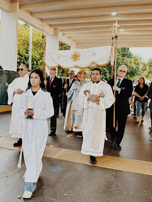 Father Dariel Fong (right), parochial vicar of St. Mark's Church in Southwest Ranches, accompanies the Eucharistic procession during the Solemnity of Corpus Christi on June 3, around the perimeter of the parish. St. Mark's pastor, Jaime Acevedo, carries the Blessed Sacrament.