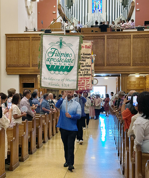 Banners from the Filipino Apostolate of Miami enter St. Mary Cathedral in Miami, at the beginning of the Mass in honor of San Lorenzo Ruiz, the first Filipino saint, celebrated by Archbishop Thomas Wenski, Sept. 29, 2024.