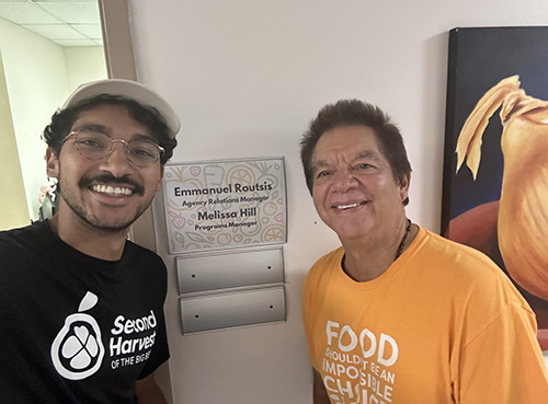 Peter Routsis-Arroyo (right), CEO of Catholic Charities Miami, poses with his son, Emmanuel Routsis, who works for Second Harvest Food Bank, which has set up food distributions throughout the area, at a food distribution site in Live Oak, in northwest Florida, Sept. 30, 2024.