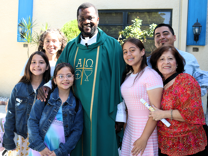 Mons. Chanel Jeanty, párroco interino de la iglesia Our Lady of Heaven, posa para la foto con la familia Román Romero después de la Misa del 3 de noviembre. Mons. Jeanty llegó a la parroquia desde principios de octubre sustituyendo al párroco, el P. Kidney St. Jean, quien está enfermo.