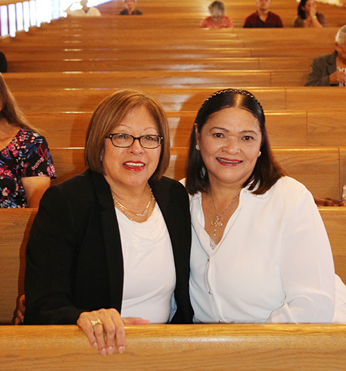 Eva Hart, left, and Mayra Garcia arrive early to Mass to pray quietly before the newly remodeled sanctuary of St. Matthew’s Church that was rededicated on Dec. 8.
