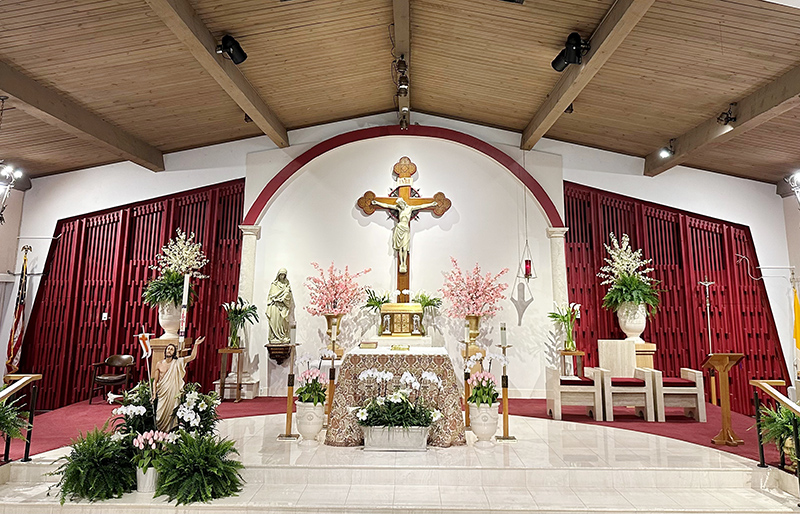 BEFORE: St. Matthew's Church sanctuary is pictured before its fall 2024 renovation with red carpet and a white plywood wall in front of the amber wood back wall.