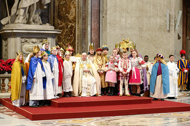 Pope Francis poses for a photo with young people -- dressed as the three kings who vistited Jesus -- during Mass in St. Peter's Basilica at the Vatican Jan. 1, 2025, the feast of Mary, Mother of God, and World Peace Day.