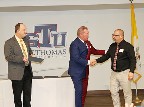 Joe Basi, performing arts chair at St. Thomas Aquinas High School in Ft. Lauderdale, right, greets St. Thomas University President David Armstrong as archdiocesan superintendent of the Office of Catholic Schools Jim Rigg looks on. St. Thomas hosted a reception on Jan. 10, 2025 for 11 incoming students and 14 preparing to graduate from a master's degree program in Catholic educational leadership developed in partnership with the Miami Archdiocese.