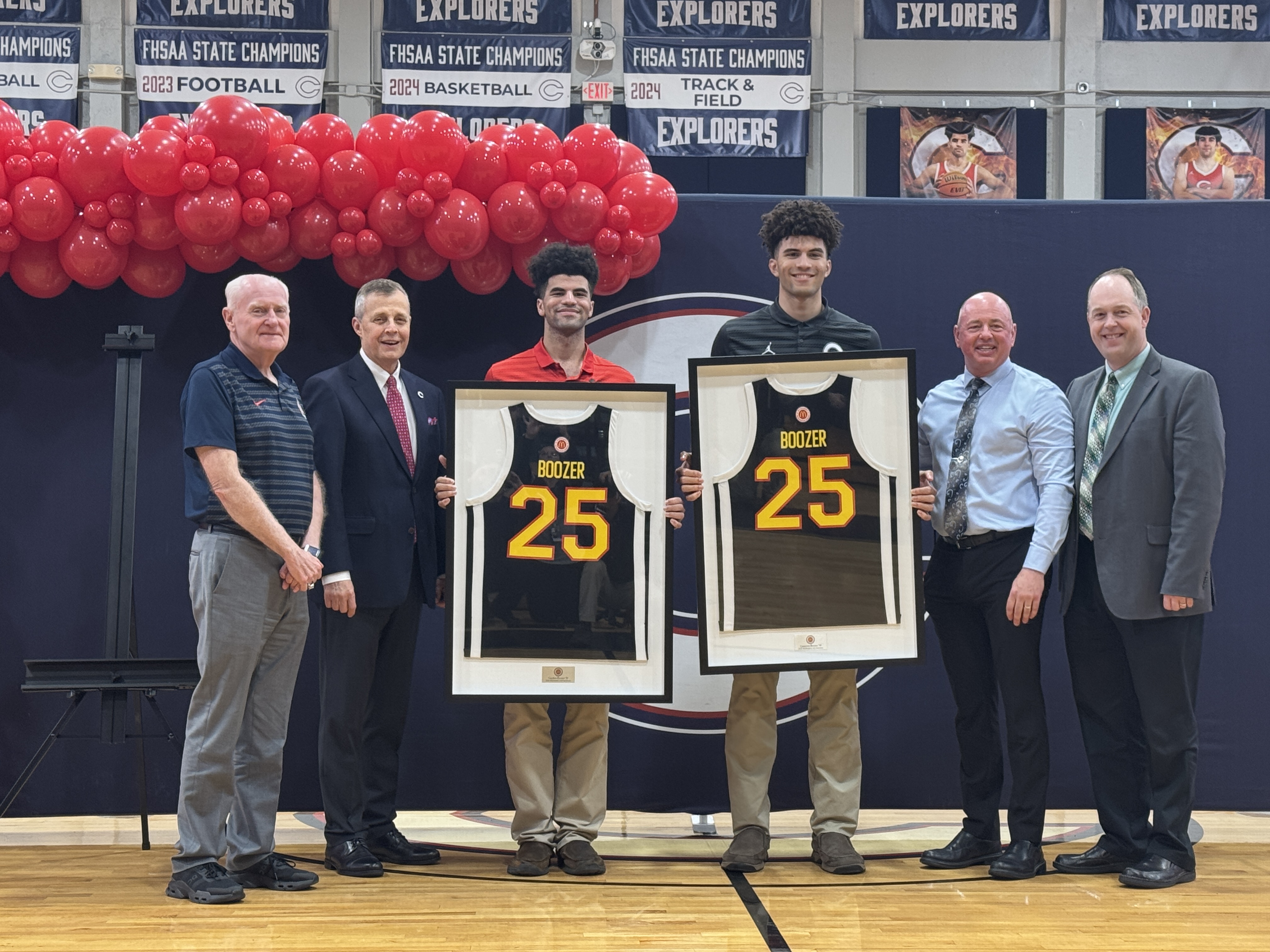 Christopher Columbus basketball stars Cayden and Cameron Boozer (center) pose with their McDonald's All American honorary jerseys presented by Columbus athletic director Chris McKeon (far left), president Thomas Kruczek, principal David Pugh, and Archdiocese of Miami superintendent of Catholic schools, Jim Rigg. The high school honored the players for their election to the 2025 McDonald's All American Games with a ceremony in the school's gymnasium Feb. 21, 2025.