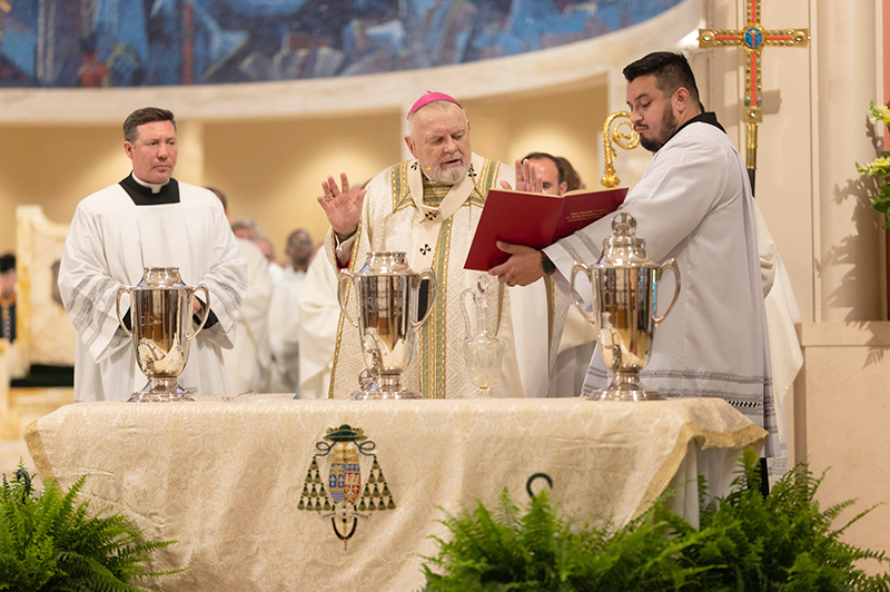 Archbishop Thomas Wenski blesses the oil of chrism, center, at the conclusion of the chrism Mass April 15, 2025.