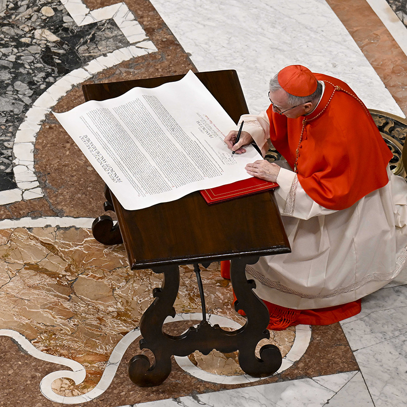 Cardinal Pietro Parolin, Vatican secretary of state under Pope Francis, signs the "rogito" or scroll describing the late pope's life, ministry and papacy April 25, 2025, during a prayer service in St. Peter's Basilica.