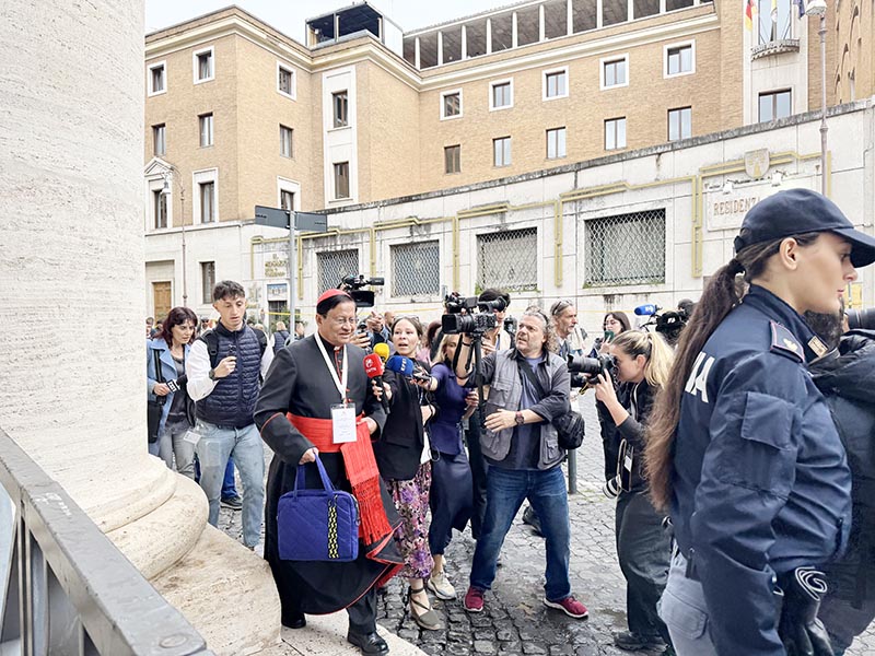 Cardinal Charles Maung Bo of Yangon, Myanmar, is surrounded by journalists near the colonnade around St. Peter's Square at the Vatican May 5, 2025, as he arrives for the cardinals' general congregation meeting.