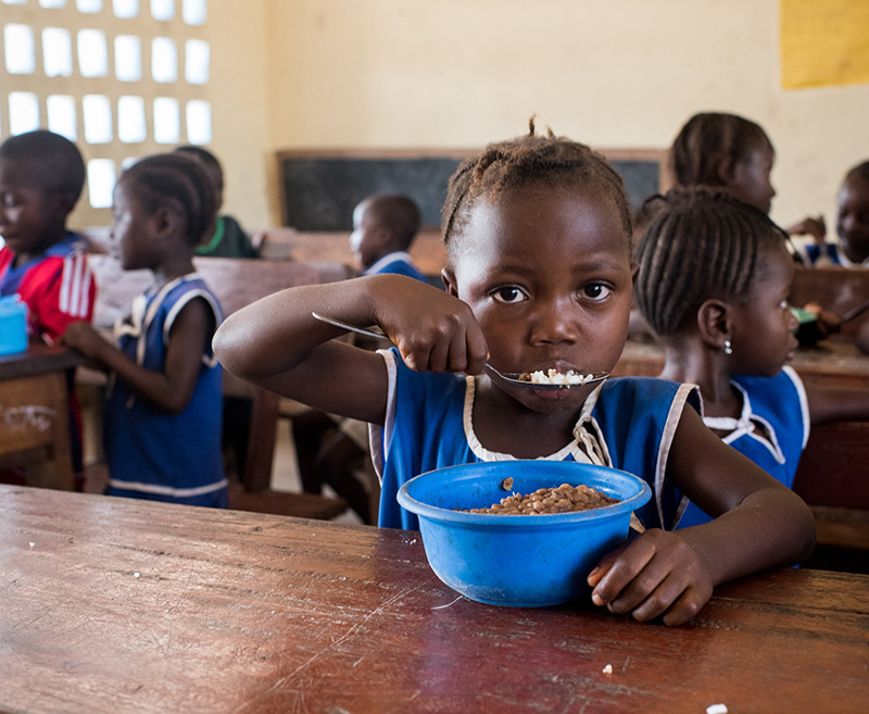 A student is pictured in a 2017 photo eating lunch at primary school in the Kumala community in Sierra Leone's Koinadugu District. At the school, volunteer parents prepare and serve warm, nutritious meals for students each day through a Catholic Relief Services' project titled, in English, "Every Child Should Be Educated." The project is part of the McGovern-Dole International Food for Education and Child Nutrition initiative sponsored and funded by the U.S. Department of Agriculture.