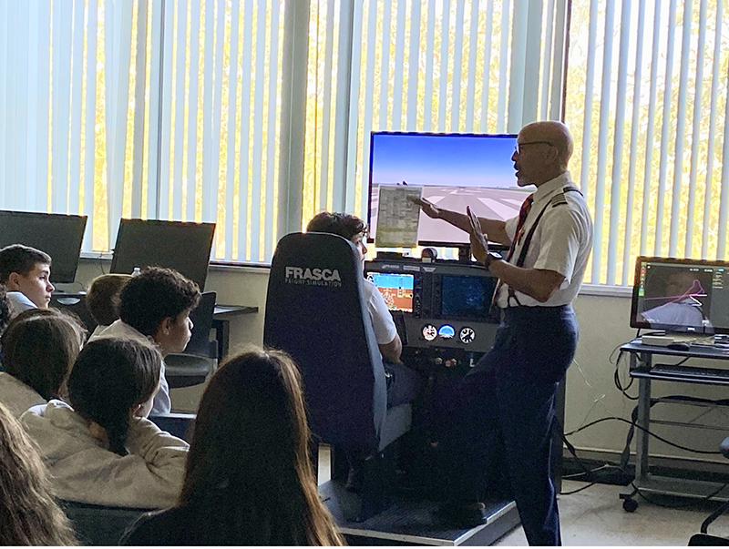 Nativity School students experience flight simulation exercises with Captain Oneida "Jay" Rollins (far right) at Florida Memorial University during a field trip on Mar. 26, 2025. Nativity students were paying tribute to the Tuskegee Airmen for Tuskegee Airmen Commemoration Day, which fell on Mar. 27 this year.