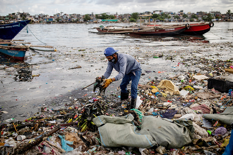 Argie Aguirre, a member of the River Warriors, gathers trash from the polluted Pasig River in Manila, Philippines, June 22, 2021. Pope Francis released his landmark environmental encyclical "Laudato Si'" 10 years ago May 14, 2015.