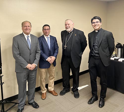 Archbishop Thomas Wenski, second from right, poses, from left, with Steve Litz, an NBC 6 reporter, Sean Foreman, Barry professor of political science, and priest secretary Father Agustin Estrada at the Barry University Institute for Immigration Studies 2nd Annual Conference in Miami Shores. The conference held April 9-10, 2025 explored the theme of “South Florida: The Hub for Immigration Innovation and Integration.”