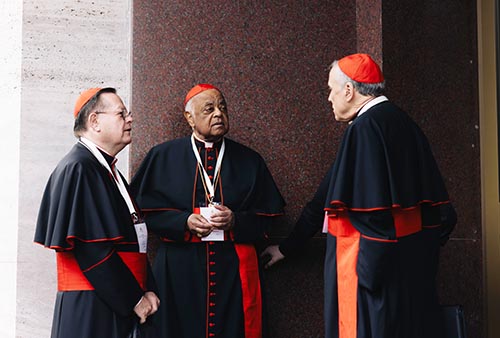Cardinals Gérald C. Lacroix of Québec, Wilton D. Gregory, retired archbishop of Washington, and Daniel N. DiNardo, retired archbishop of Galveston-Houston, speak outside the Pontifical North American College in Rome May 5, 2025. The three cardinals will enter the conclave to elect a new pope May 7.