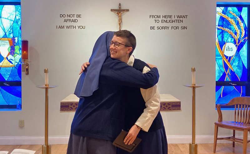 Catherine Addington is embraced by a Daughter of St. Paul after professing her vows. Addington is now a novice with the order.