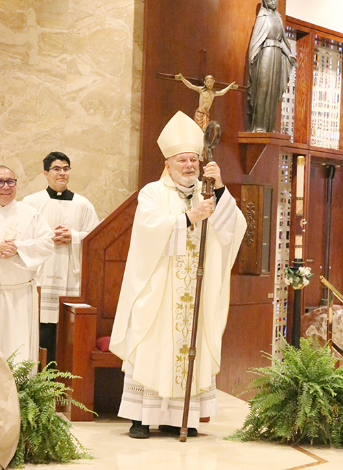 Archbishop Thomas Wenski announces the election of a new Pope, Leo XIV, at the end of a Mass he celebrated for the election of a new Pope on May 8, 2025, at St. Martha Church in Miami Shores. Standing next to him, from left, are Deacon Edgardo Farias, archdiocesan director of Prison ministry, and Father Agustin Estrada, priest secretary to the archbishop.