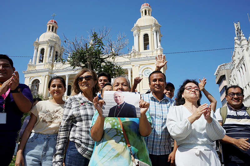 A woman holds an image of then-Cardinal Robert Francis Prevost in front of the Cathedral of St. Mary in Chiclayo, Peru, May 8, 2025, after he was elected the pope at the Vatican and chose the name Leo XIV. As an Augustinian priest, he spent many years as a missionary in Peru.