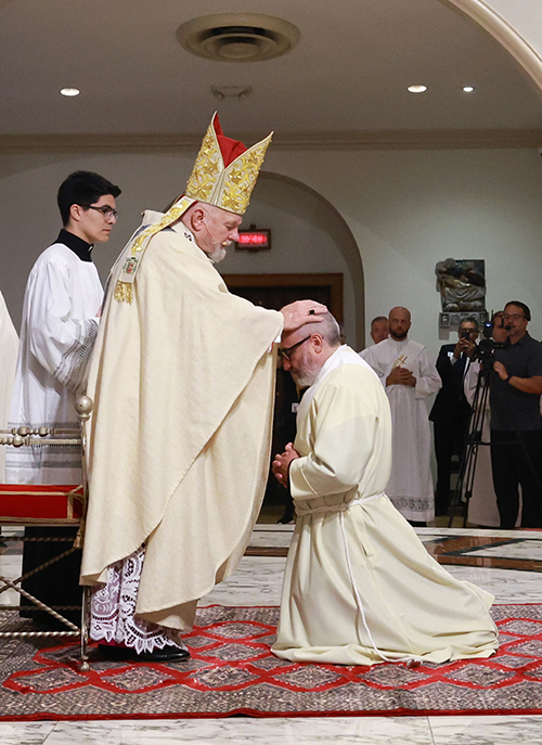 Archbishop Thomas Wenski lays hands on Deacon Jorge Reyes, one of two men he ordained to the priesthood for the Archdiocese of Miami, May 10, 2025, at St. Mary Cathedral.