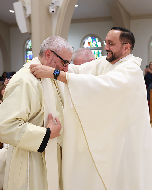 Father Julio De Jesus, pastor of St. John XXIII parish in Miramar, right, vests newly ordained Father Jorge Reyes at the ceremony where Archbishop Thomas Wenski ordained two men to the priesthood for the Archdiocese of Miami, May 10, 2025, at St. Mary Cathedral.