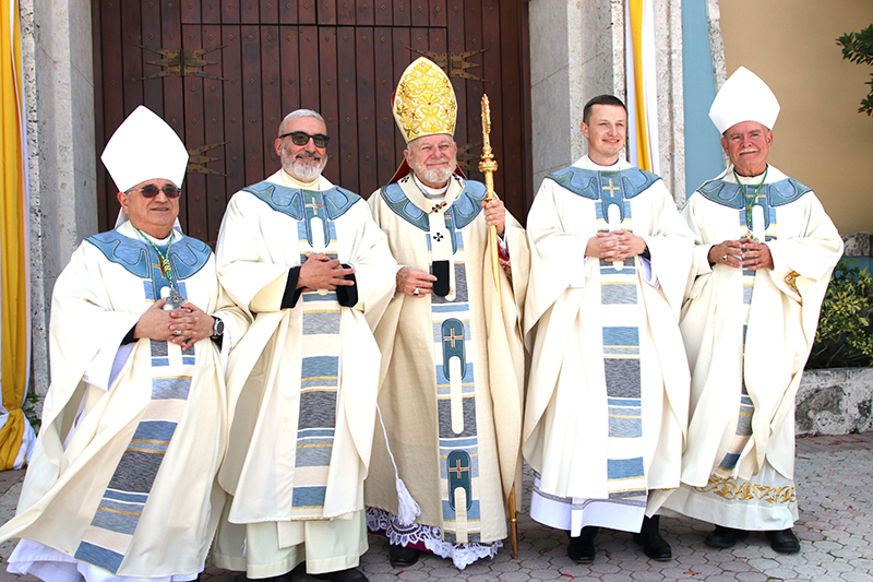 The newly ordained pose for a photograph with the bishops, from left: Miami Auxiliary Bishop Enrique Delgado; Father Jorge Reyes; Archbishop Thomas Wenski; Father Jakub Bereza; and Bishop Fernando Isern, emeritus of Pueblo, Colorado, after the ordination ceremony May 10, 2025, at St. Mary Cathedral in Miami.