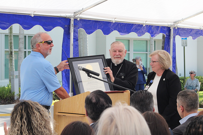 During the unveiling and blessing ceremony for the new statue of St. Catherine Labouré, May 15, 2025, the City of Hialeah Gardens presented St. Catherine's West Rehabilitation Hospital in Hialeah Gardens with the Mayor's Award for Distinguished Public Service. City Council Member Roly Piña presented the award to Archbishop Thomas Wenski and Mary Jo Frick, president and CEO of Catholic Health Services.