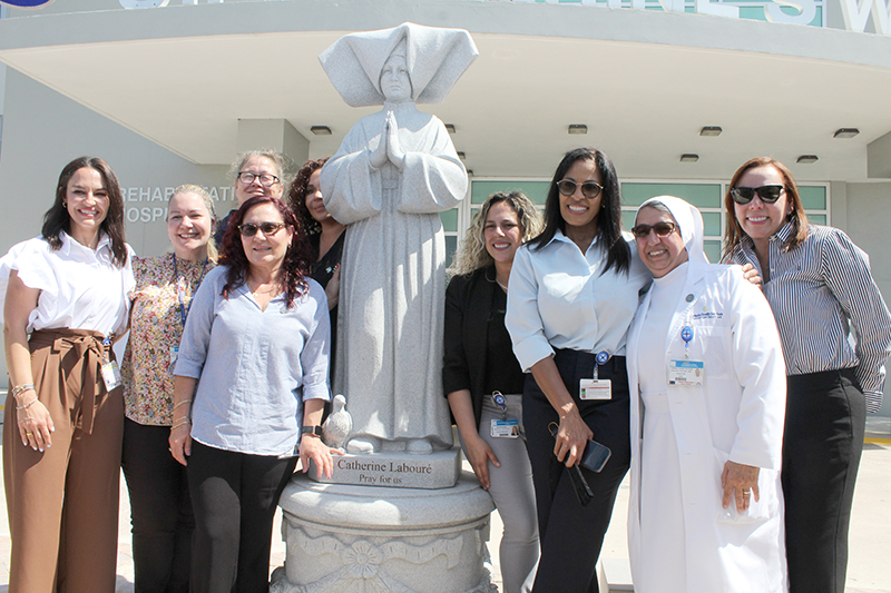 Staff of Catholic Health Services and St. Catherine's West Rehabilitation Hospital in Hialeah Gardens posed with the center's new statue of St. Catherine LabourŽ. From left to right: Christina Sierra, Anais Correa Gomez, Lorraine Orozco, Lilliam Amador, Sandra Nunez, Liset Rodriguez, Mother Yolanda Tostado, and Gloria Hasbun.