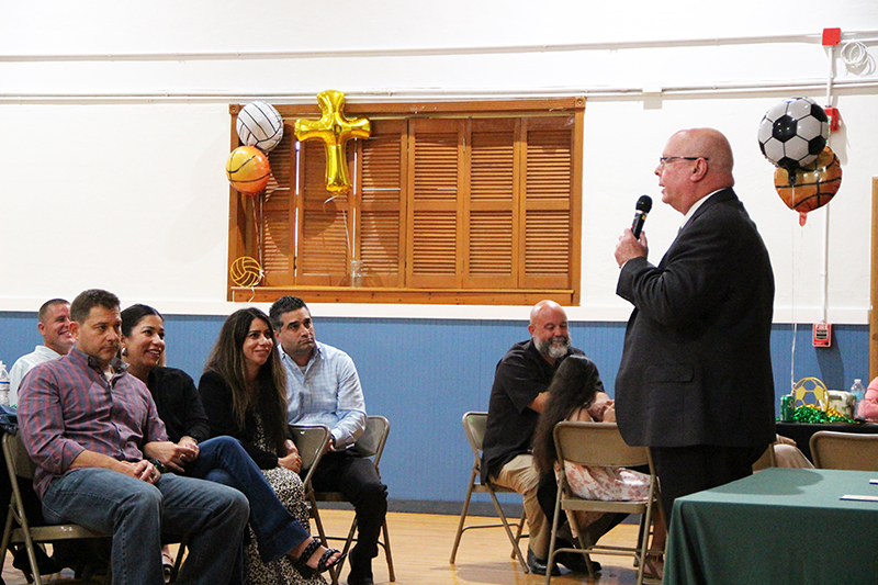 Irvin Bruce (right) shares his story about forging bonds within Catholic athletics as guest speaker at Little Flower School’s 2024-25 Sports Awards Banquet May 22, 2025, celebrating the achievements of the school’s athletes.