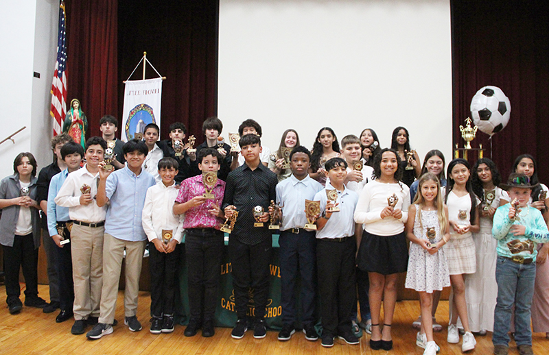 Student athletes smile showing their awards for the camera at Little Flower School’s 2024-25 Sports Awards Banquet in Hollywood May 22, 2025.