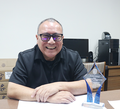 El diácono Edgardo Farías, director del Ministerio Arquidiocesano de Prisiones, en su oficina del Centro Pastoral, con el premio otorgado a la Arquidiócesis como la Organización Religiosa del Año 2025.