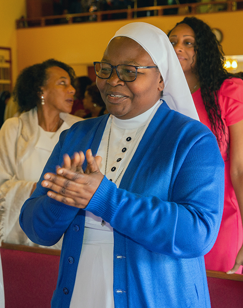 Sister Mary Angela Ogoke, a Daughter of Mary Mother of Mercy claps to the music during Mass at which Archbishop Thomas Wenski installed Spiritan Father Fidelis Nwankwo as the pastor of St. Philip Neri Church in Miami Gardens, June 22, 2025.