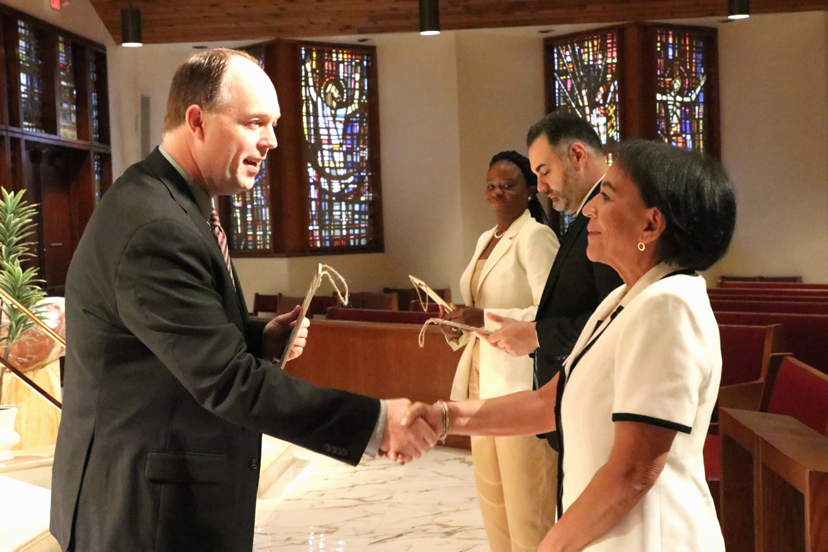 Newly named school Principal Renee Sarmiento shakes hands with Jim Rigg, Superintendent of archdiocesan schools, at a welcome Mass for new principals July 2, 2025 at the Pastoral Center. Sarmiento will be leading St. Andrew School in Coral Springs this upcoming academic year.