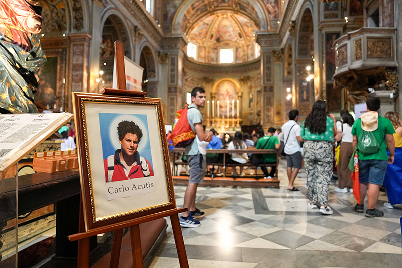 Pilgrims gather near a portrait of Blessed Carlo Acutis at the Church of San Marcello al Corso in Rome, where his relics are displayed July 31, 2025, during the Jubilee of Youth, ahead of his Sept. 7 canonization.