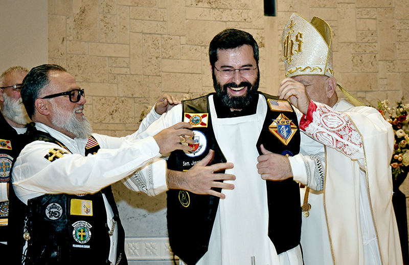 Jonathan A. Sanchez, a seminarian for the Archdiocese of Miami, laughs as he's vested as a member of the Knights on Bikes Aug. 13, 2025, at St. Elizabeth Ann Seton Church, Coral Springs. The vesting took place during the 40th anniversary Mass for the Knights of Columbus Council 8838.