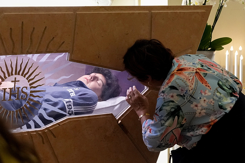A woman prays at the tomb of Blessed Carlo Acutis in the Shrine of the Renunciation in Assisi, Italy, Aug. 21, 2025. Acutis, who died in 2006 at age 15, will be canonized Sept. 7 at the Vatican by Pope Leo XIV.