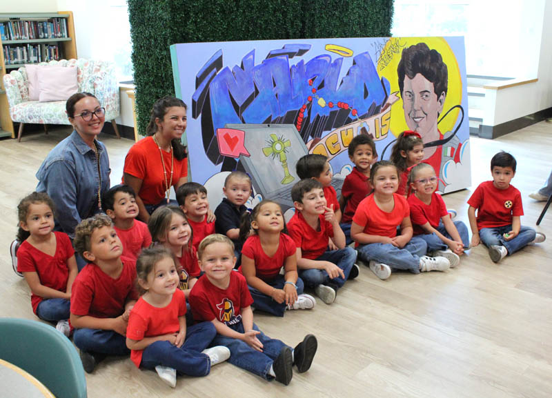 St. Louis Covenant School PreK-4 instructional assistant Anabelle Ramos and teacher Caterina Villavicencio posed with their students in front of a mural of St. Carlo Acutis during a "Canonization Celebration" held in his honor at their school in Pinecrest on Sept. 5, 2025. The mural was created by Art teacher Erick Nieto and the after-school art club.