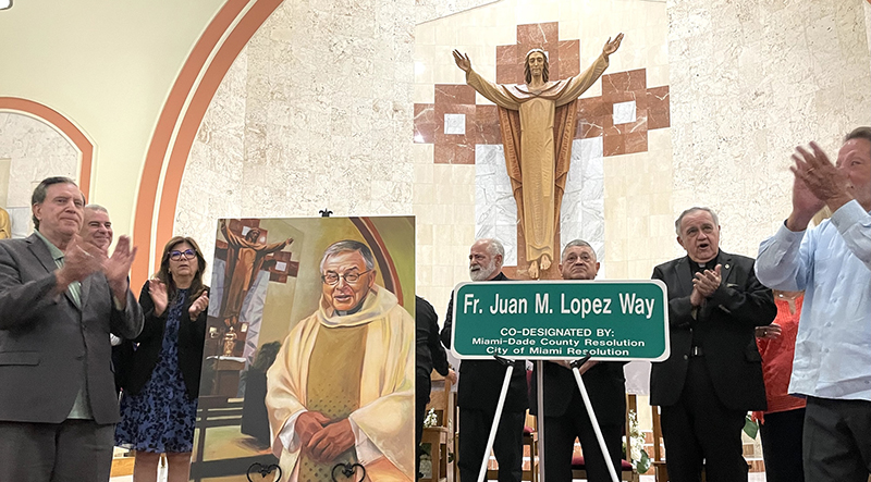 Attendees at the ceremony to name a street in honor of Father Juan López, pastor of St. Peter and Paul Church in Miami for 34 years, applaud as the sign is unveiled Sept. 12, 2025. Due to persistent rain, the ceremony took place inside the church.