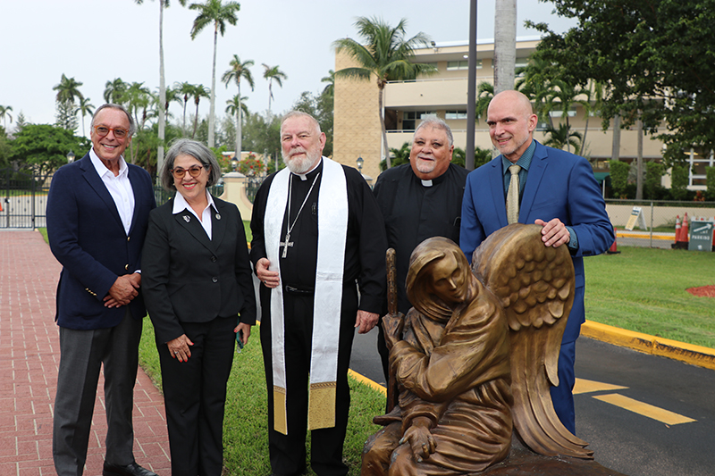 El Arzobispo Thomas Wenski (centro)después de bendecir la escultura Be Welcoming, que fue instalada en La Ermita de la Caridad el 22 de agosto de 2025, posa para la foto con, desde la izquierda; Mike Fernandez, empresario y filántropo que dono la escultura; Daniella Levin Cava, alcaldesa del condado de Miami-Dade; el P. José Espino, rector de La Ermita y Timothy Schmalz, escultor.